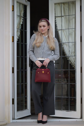 a lady in a shirt, a grey pearl sweater jacket and a pair of black pants